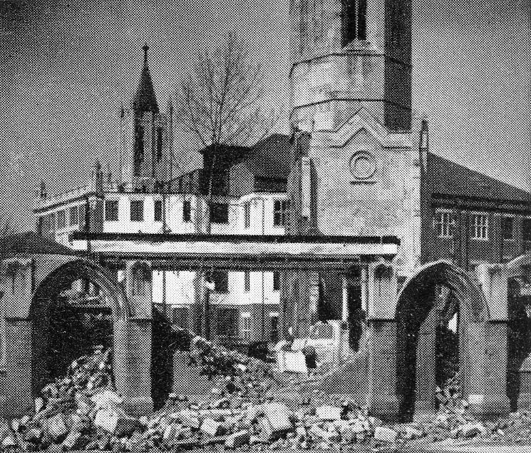 Image ashowing the ruins of Christchurch being cleared away, with the ancient spire remaining.