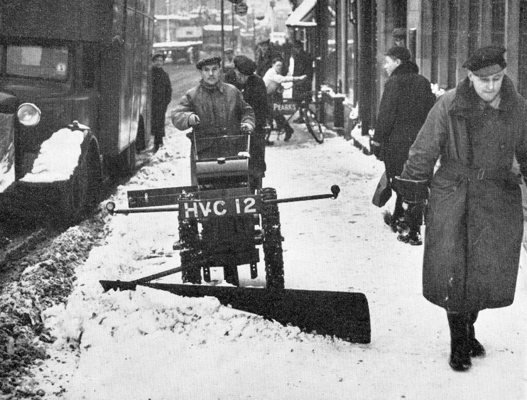 Image showing a man guiding a hand held snow plough on pavements in Coventry