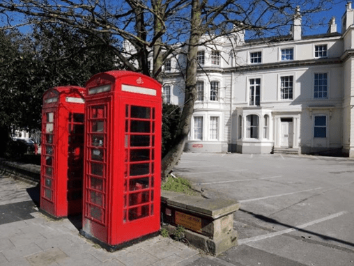 Photograph of two K5 phone boxes in Warwick Row. The photo shows the two boxes with Georgian houses below.
