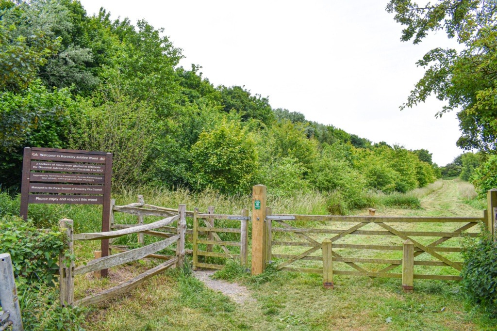 Photograph of the entrance to Keresley Jubilee Wood showing a notice board to the left and gates and paths.