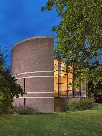 Photograph of Fitzwilliam College Chapel showing a curved all and an illuminated facade.