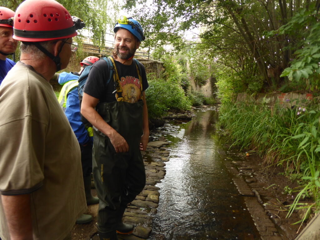 Photograph of a group of people with helmets about to enter the river.