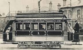 Monochrome image of an electric tram, with the driver standing at the back. The tram has a sign "The Coventry Electdic Tramways Ltd" on the side.