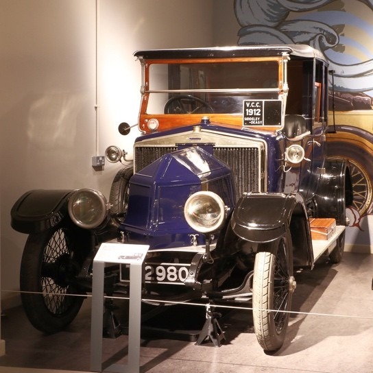 Coloured image of an old car in a transport museum