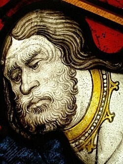 Close up image of one of the panels of the Great East window, showing a bearded face and a stern expression. 