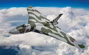 Colour image of a delta wing aircraft with clouds behind.