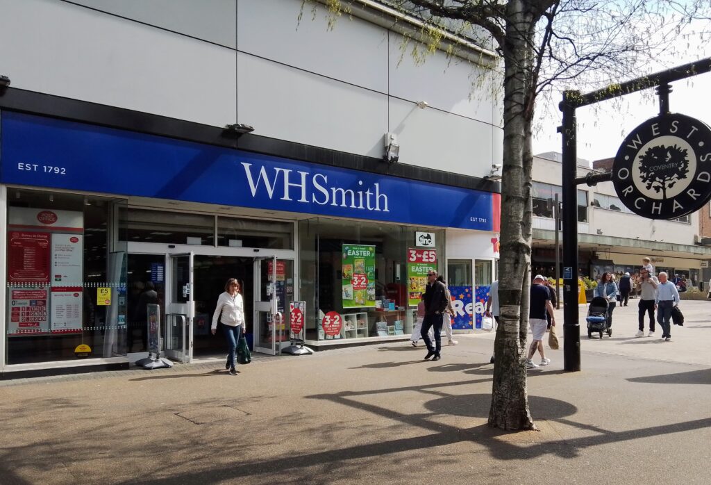 Colour photograph of WH Smith in the West Orchard shopping centre, Coventry. The shop frontage is on the left and a circulars West Orchard sign to the right.  