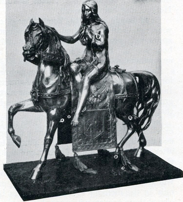 Monochrome image of a small statue of Lady Godiva sitting on a horse 